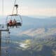 Two people riding up a ski lift in the summertime