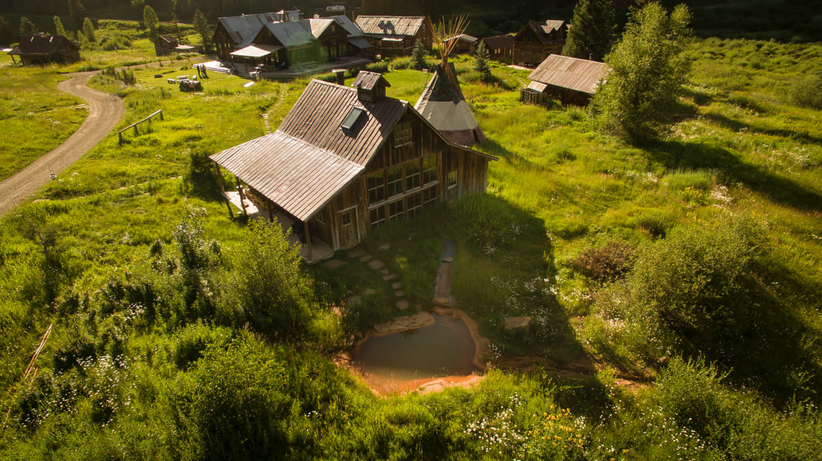 Aerial view of rustic cabin and hot spring