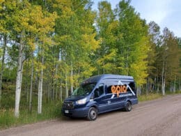 Black Epic Mountain Adventures van on a forest road