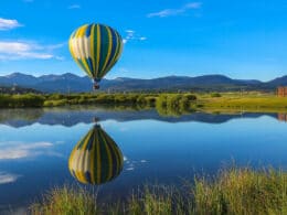 Image of a Grand Adventures Balloon Tours hot air balloon over water in Fraser, Colorado