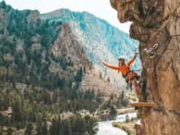 Image of a woman on the Granite Via Ferrata hanging off the cliff in Buena Vista, Colorado