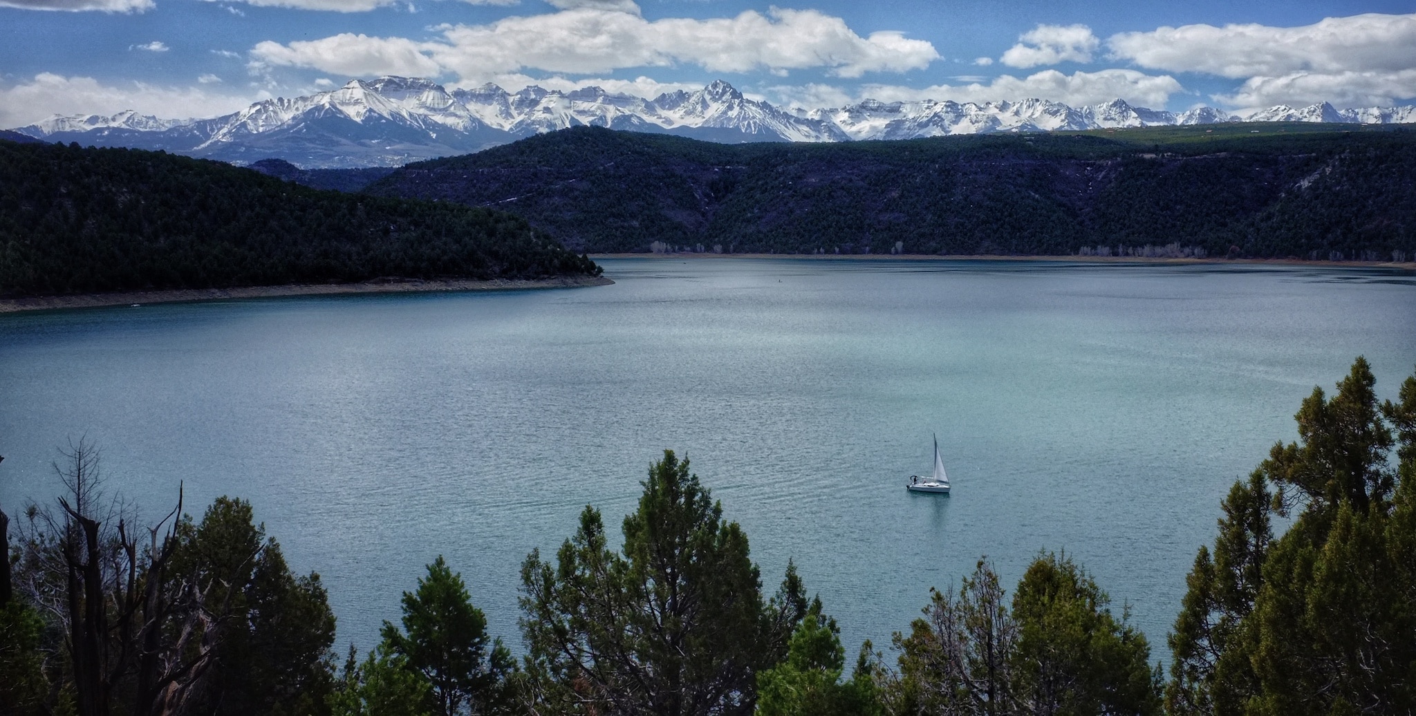 A large reservoir outside of Ridgway, Colorado with snowcapped peaks in the distance.